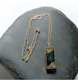 Pendentif en résine noire et dorée , fleur séchée naturelle verte .