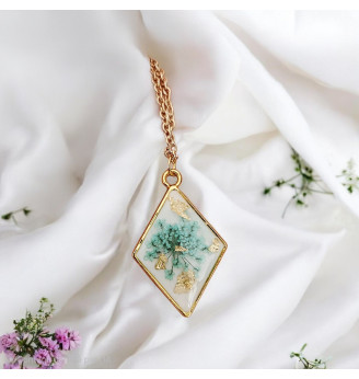 Pendentif en résine, losange doré et fleur naturelle turquoise – Fond blanc .