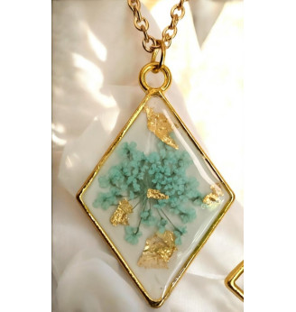 Pendentif en résine, losange doré et fleur naturelle turquoise – Fond blanc .