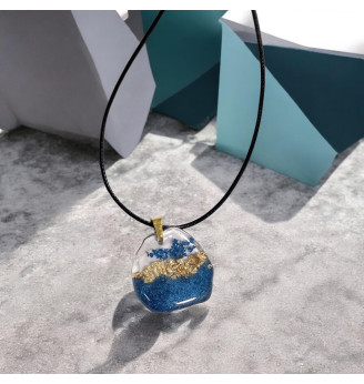 Pendentif en résine cristal  , forme libre, fleur séchée bleue et feuilles dorées