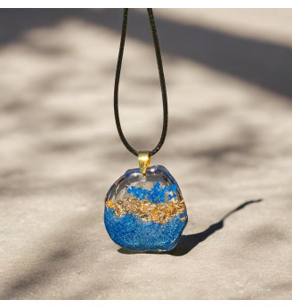 Pendentif en résine cristal  , forme libre, fleur séchée bleue et feuilles dorées